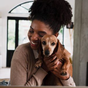 A woman holding her dog in her arms.