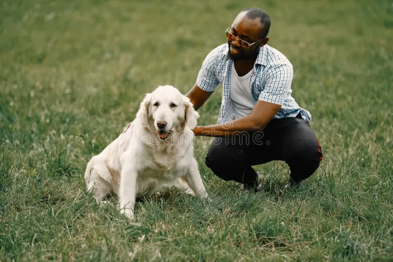 A boy and his dog laying in the grass.
